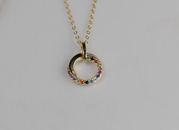 Detalle de pendiente dorado con piedras de colores