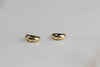 Argollas de plata 925 con baño de oro 18k con zirconias sobre superficie blanca