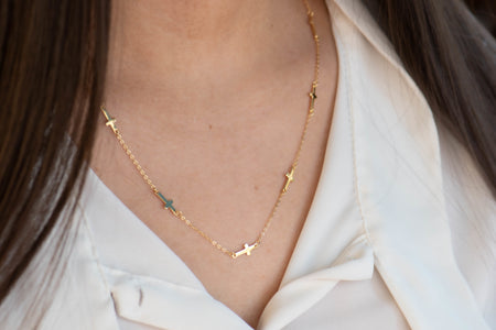 modelo con collar de cadena con cruces color oro