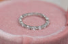 Anillo en plata 925 con Zirconias incrustadas al rededor de la argolla exhibido sobre una caja de anillo rosa en Guatemala