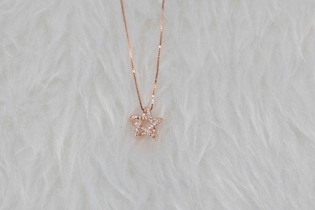 Collar cadena con pendiente de estrella en color oro rosa y zirconias en superficie