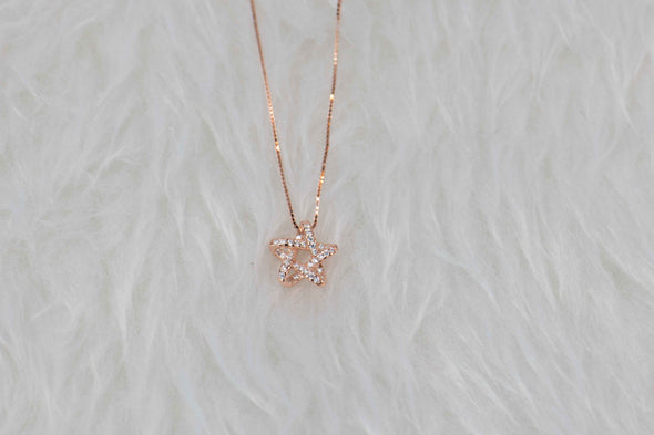Collar cadena con pendiente de estrella en color oro rosa y zirconias en superficie
