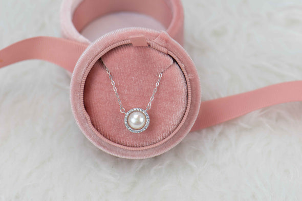 Collar de cadena color plata con pendiente de perla y zirconias incrustadas en caja de joyas rosa