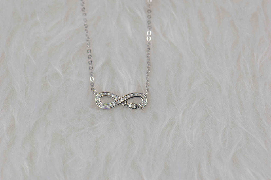 Detalle de collar de cadena y pendiente de infinito con palabra mamá- Mom en plata 925