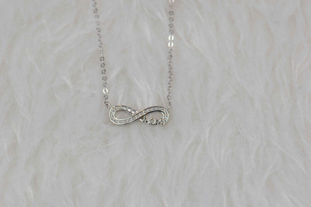 Detalle de collar de cadena y pendiente de infinito con palabra mamá- Mom en plata 925