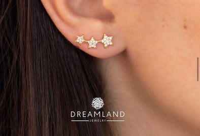 Modelo con Aretes tipo climbers de estrellas con baño de oro 18k