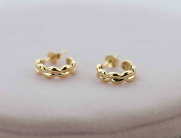 Aretes de argolla de plata 925 con baño en oro 18k exhibidas sobre mesa
