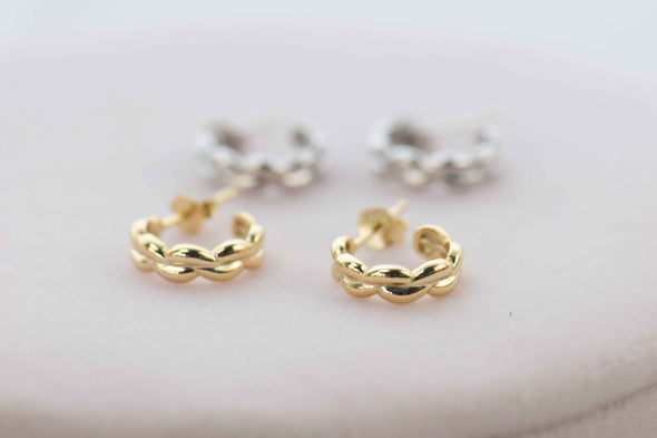 Aretes de argolla de plata 925 con baño en oro 18k y Aretes de argolla de plata 925 exhibidas sobre mesa