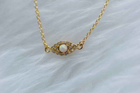 Detalle de collar con cadena y pendiente de ojo con ópalo sintético con baño de oro 18k
