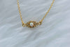 Detalle de collar con cadena y pendiente de ojo con ópalo sintético con baño de oro 18k