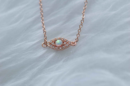 Detalle de collar con cadena y pendiente de ojo con ópalo sintético con baño de oro rosa 18k