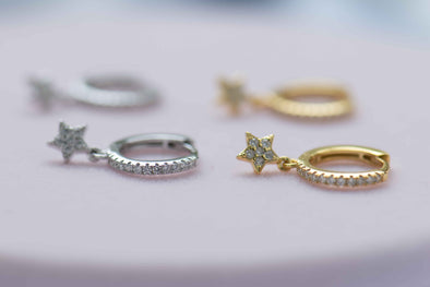 Un par de argollas incrustadas en zirconias blancas con pequeña estrella colgante con baño de oro 18k, Un par de argollas incrustadas en zirconias blancas con pequeña estrella colgante en plata 925