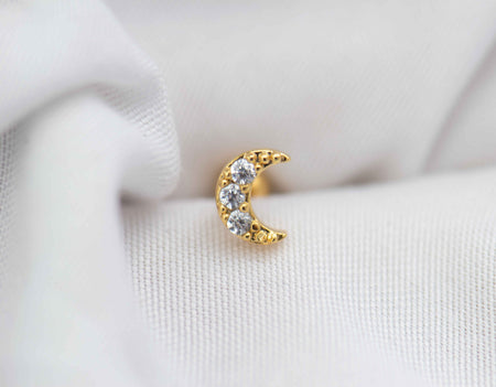 Detalle de arete piercing de Luna color oro con piedras zirconias blancas