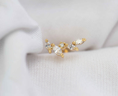 Detalle de arete piercing de racimo de hojas color oro con piedras zirconias blancas