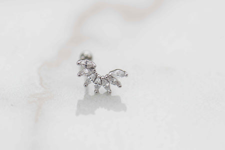 Detalle de arete piercing de 7 hojas color plata con piedras zirconias blancas