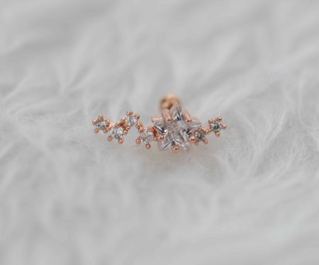 Arete piercing en acero inoxidable con frente de cobre y estrella en circonita en color oro rosa exhibido en Guatemala