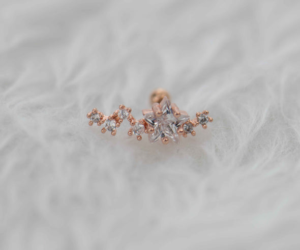 Arete piercing en acero inoxidable con frente de cobre y estrella en circonita en color oro rosa exhibido en Guatemala