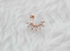 Detalle de arete piercing de 7 hojas color oro rosa con piedras zirconias blancas
