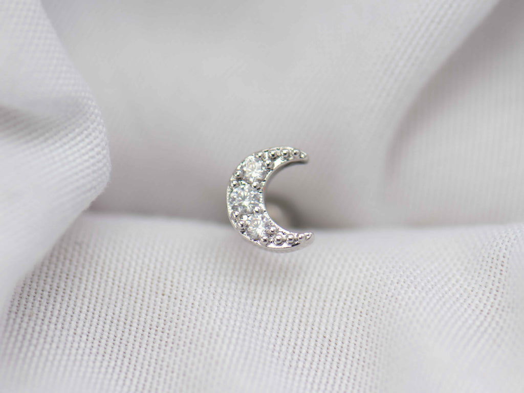 Detalle de arete piercing de Luna color plata con piedras zirconias blancas