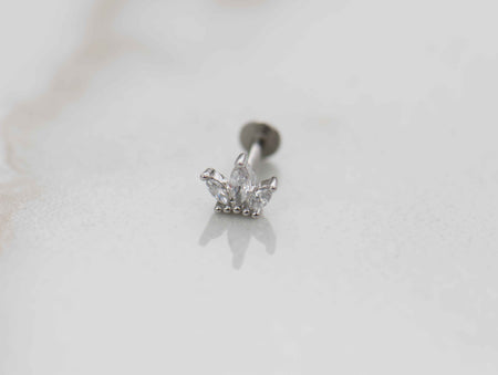 Detalle de arete piercing de corona color plata con piedras zirconias blancas