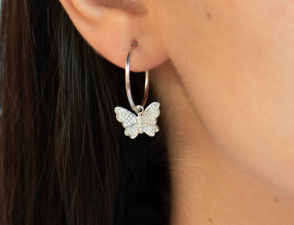 Modelo usando una argolla en plata 925 con mariposa colgante con zirconias