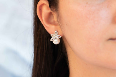 Modelo con arete de perla de fantasía y flor encobre con zirconias