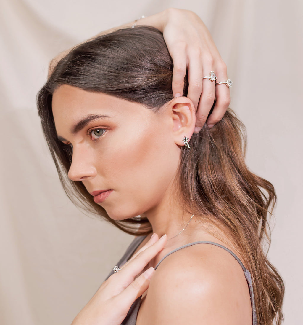 Modelo usando aretes de plata 925 en formade recimo de hojas con Zirconias pequeñas y otros anillos y collar de la colección de Dreamland