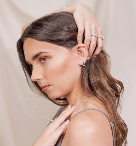 Modelo usando aretes de plata 925 en formade recimo de hojas con Zirconias pequeñas y otros anillos y collar de la colección de Dreamland