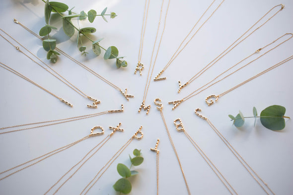 Collares con pendientes de letras color oro