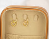 Aretes colgantes de corazón en plata 925 con baño de oro 18k exhibidos en un joyero color beige de venta en Guatemala