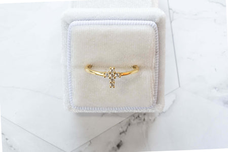 Anillo de plata 925 con baño de oro 18k y Circonitas formando una cruz exhibido en caja de anillo blanca en Guatemala