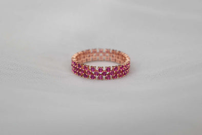 Anillo de plata 925 con baño de oro 18k y Zirconias color rosa exhibido sobre una superficie blanca
