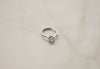 Anillo de plata 925 ajustable con zirconia central grande exhibido sobre superficie blanca