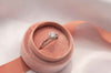 Anillo de plata 925 ajustable con zirconia central grande exhibido dentro de caja de anillo rosa