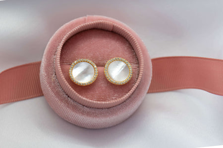 Aretes de plata 925 con baño de oro 18k y Concha Nacar exhibido en caja de aretes rosa