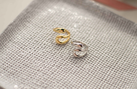 Anillo en plata 925 y Anillo en plata 925 con baño de oro de 18k exhibidos sobre bandeja gris texturizada