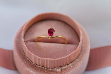 Anillo en plata 925 con baño en oro 18k con argolla lisa y delicada y piedra central de zirconia color rojo morado