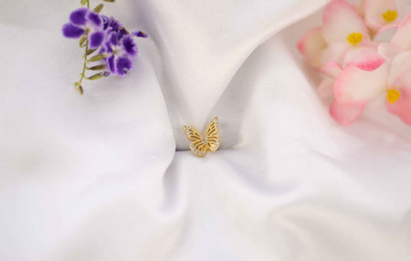 Alas de mariposa color dorado sobre seda blanca
