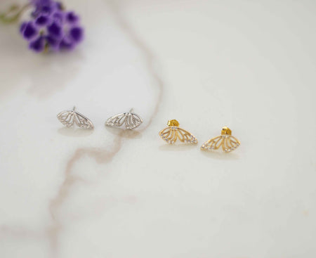 Alas de mariposa color plata y Alas de mariposa color dorado sobre superficie de mármol