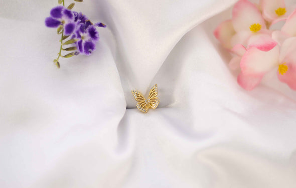 Alas de mariposa color dorado sobre seda blanca