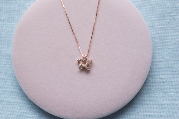 Collar cadena con pendiente de estrella en color oro rosa y zirconias en superficie rosa