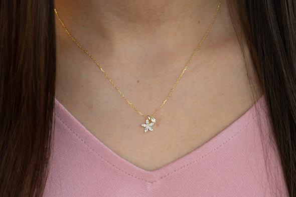 modelo con collar de cadena con pendiente de flor en zirconia color oro