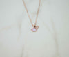 Detalle de collar de cadena con pendiente de pétalos de rosa en baño de oro rosa 18k