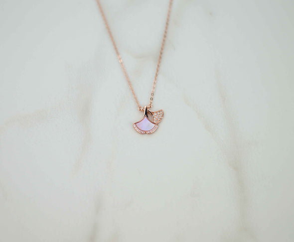 Detalle de collar de cadena con pendiente de pétalos de rosa en baño de oro rosa 18k