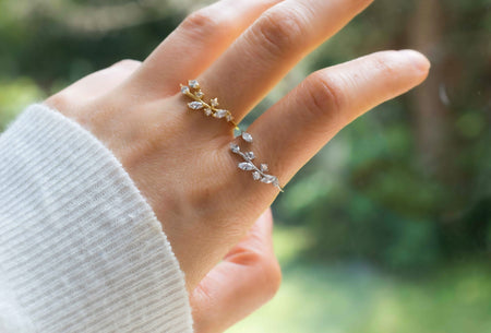 Mano con Anillo en plata 925 con hojas en zirconias blancas y anillo con baño de oro 18k con hojas en zirconias blancas