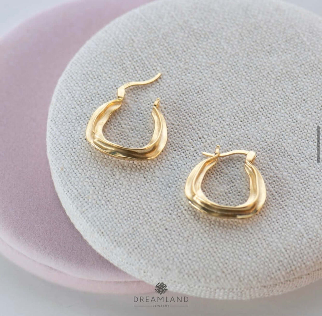 Aretes argolla dorados gruesos sobre tela