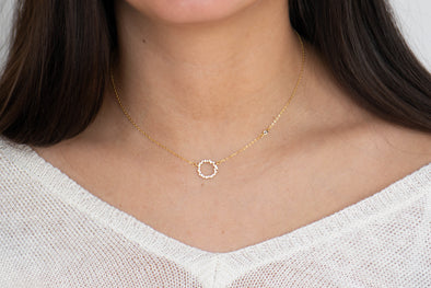 Modelo con collar de cadena y circulo incrustado en zirconias con baño de oro 18k