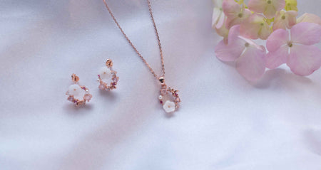 Collar con pendiente y aretes en baño de oro rosa 18k de flores y mariposa en piedras tonos rosa