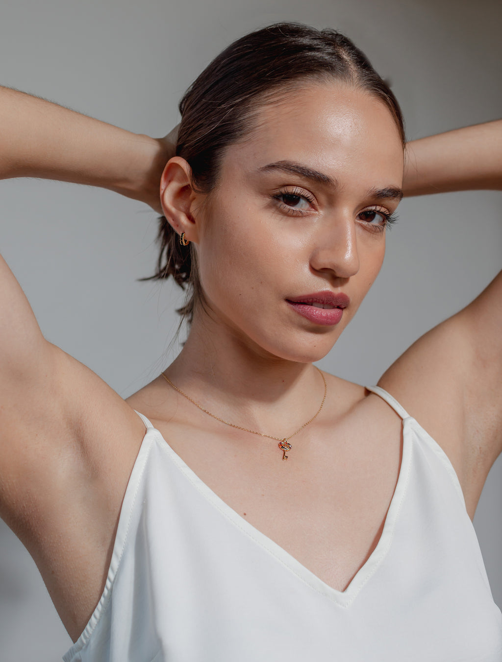 Modelo con collar con pendiente de llave en forma de corazón con marco incrustado con zirconias de colores y aretes de colección Dreamland Guatemala