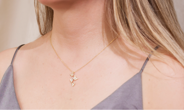 modelo con collar con cadena y pendiente de cuatro mariposas color oro con zirconias